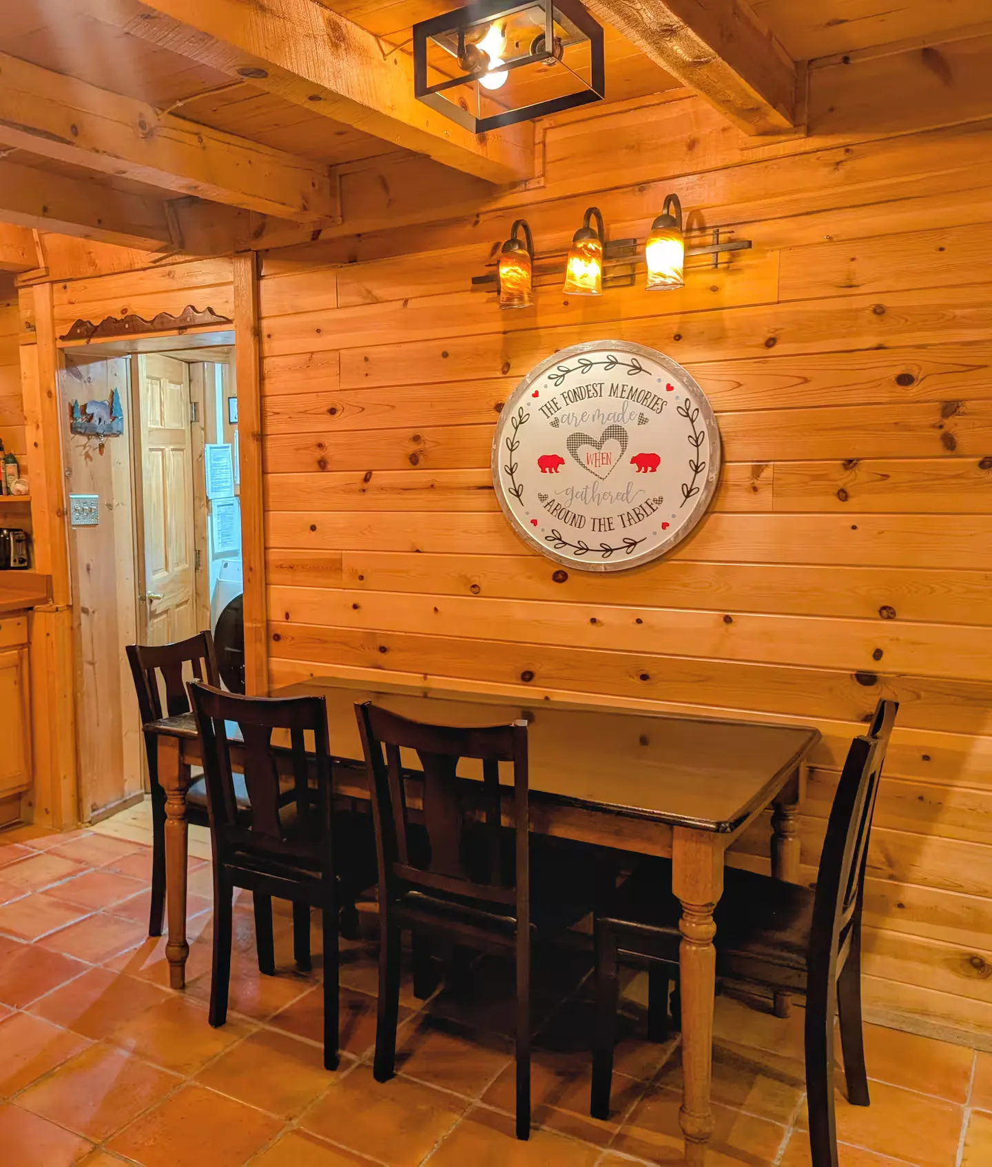 The dining table set for six beside the windows.